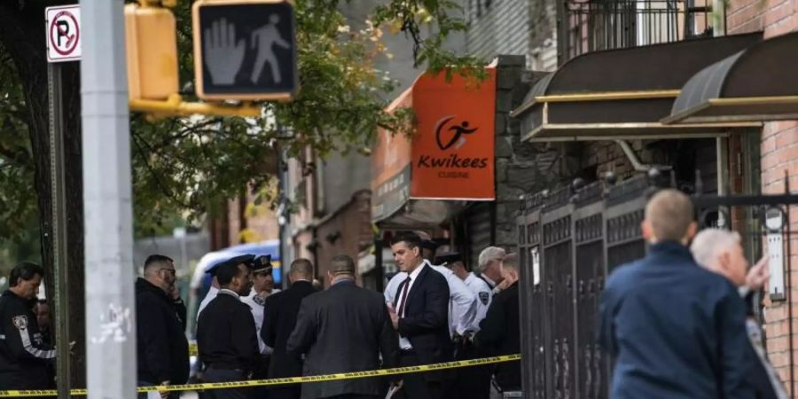 Polizisten stehen vor dem Haus in New York, in dem vier Menschen starben und drei verletzt wurden. Foto: Jeenah Moon/FR171682 AP/dpa