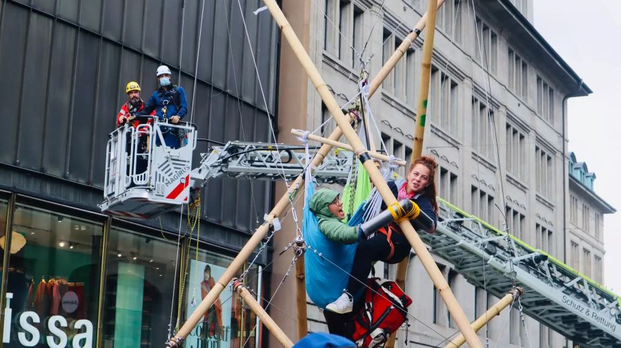 Feuerwehrleute nähern sich den beiden Aktivisten.