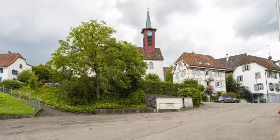 Der Dorfkern Schönenbuch mit der römisch-katholischen Kirche St. Johannes der Täufer und einem Fachwerkhaus.