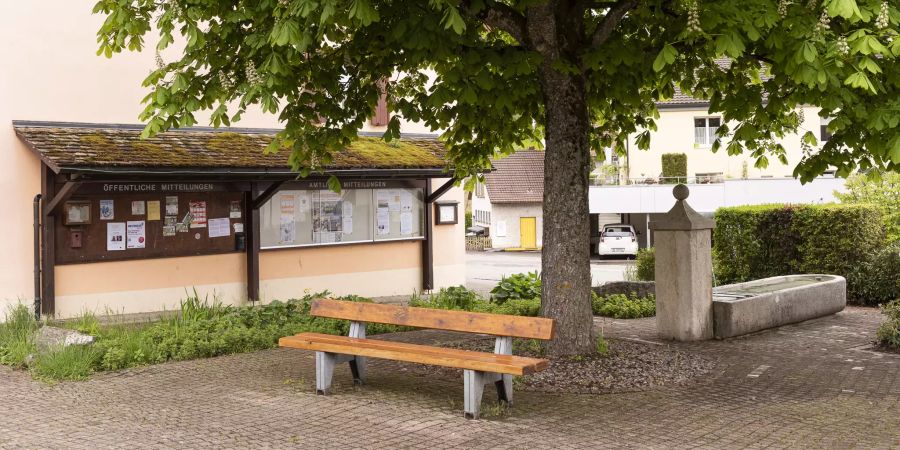 Ruhebank, Brunnen und Mitteilungstafel der Gemeinde in Läufelfingen.