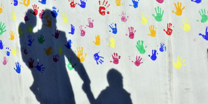 Schon sehr früh sollten Eltern beginnen, ihre Kinder für Vielfalt zu sensibilisieren. Wand bunte Handabrücke Schatten erwachsene Person zwei Kinder