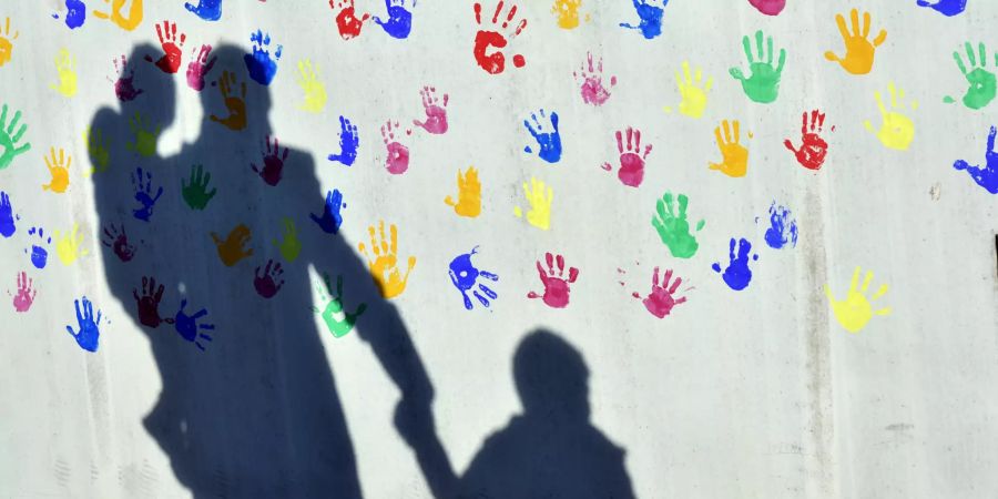 Wand bunte Handabrücke Schatten erwachsene Person zwei Kinder