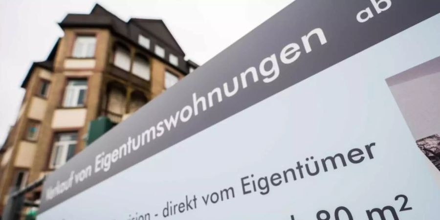 Ein Schild wirbt an einem Bauzaun im Frankfurter Stadtteil Ostend für Eigentumswohnungen. Die Wohnfläche wird hier ab 8000 Euro/je Quadratmeter angeboten. Foto: Andreas Arnold/dpa