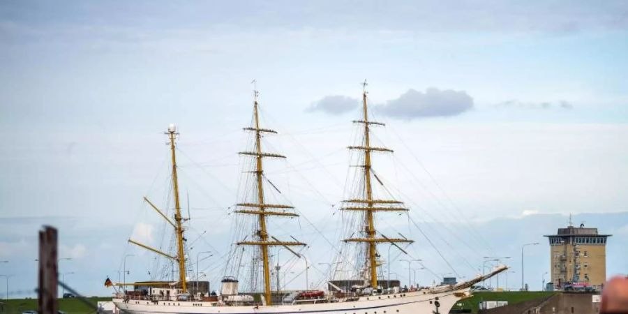 Spaziergänger beobachten die «Gorch Fock» im Marinehafen. Foto: Sina Schuldt/dpa