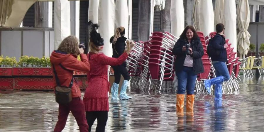 Menschen auf dem überfluteten Markusplatz in Venedig. Foto: Matteo Tagliapietra/LaPresse/dpa