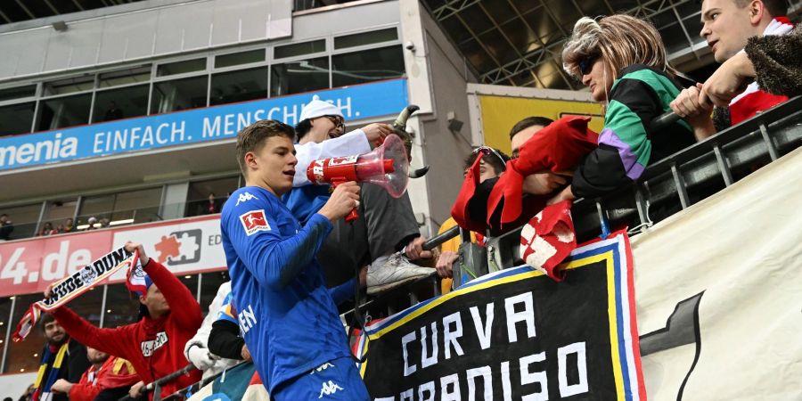 Der Mainzer Torwart Finn Dahmen feiert den Sieg in Leverkusen mit den mitgereisten Fans.