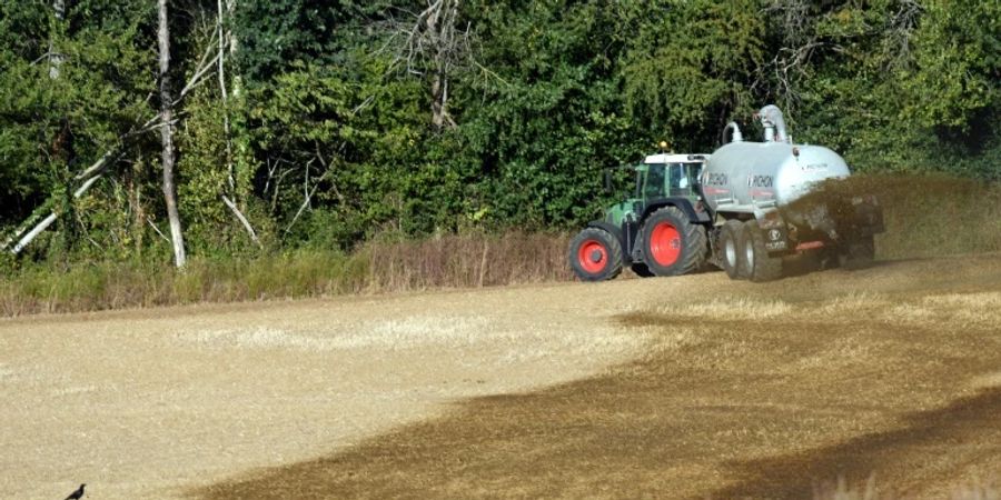 Traktor mit Güllefass auf einem Feld