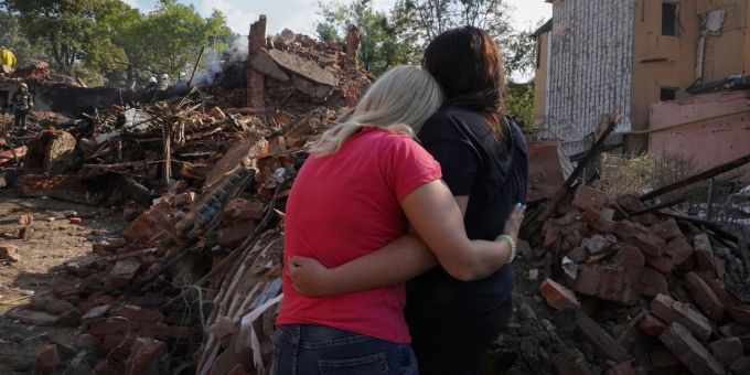 Ukrainische Frauen stehen vor den Trümmern eines Hauses in Charkiw, das bei einem Raketenangriff zerstört wurde. Ukrainische Frauen stehen vor den Trümmern eines Hauses in Charkiw, das bei einem Raketenangriff zerstört wurde.
