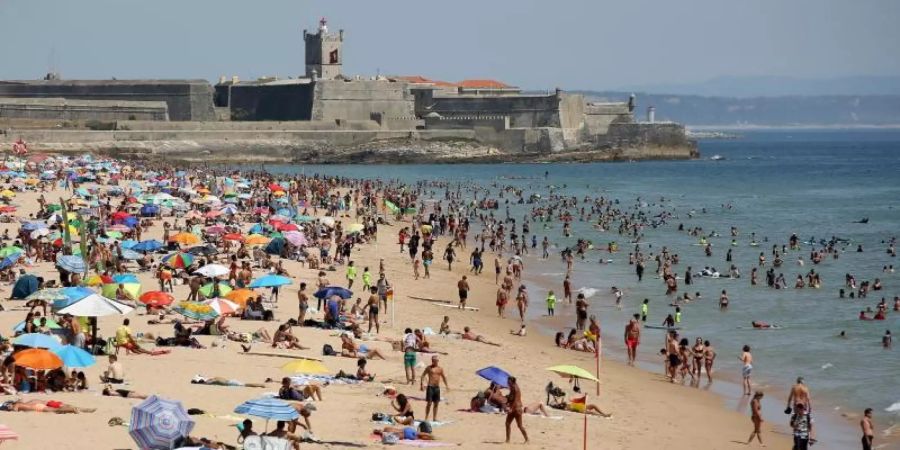 Strandbesucher an einem heissen Nachmittag am Strand Carcavelos. Foto: Pedro Fiuza/XinHua/dpa