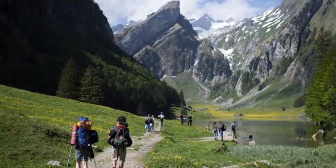 Touristen sind unterwegs am Seealpsee, einem beliebten Ausflugsziel im Alpstein-Gebirge. Wandern in der Schweiz