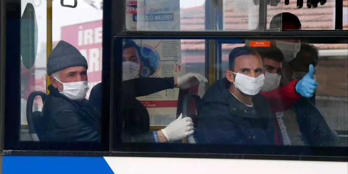 Entlassene Häftlinge mit Schutzmasken sitzen in einem Bus. Coronavirus - Türkei
