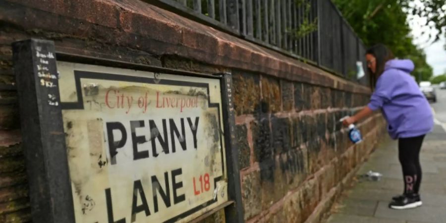 Anwohnerin entfernt Graffiti in der Penny Lane