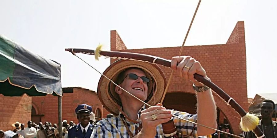 Der damalige Bundespräsident Joseph Deiss 2004 in Koudougou, Burkina Faso, mit einem Gastgeschenk. Wie der Magistrat zielten schon die frühesten Asiaten in die Luft: Vor 48'000 Jahren schossen sie im Dschungel Tiere mit Pfeil und Bogen von den Bäumen. (Archivbild)