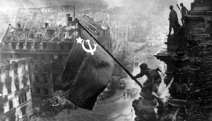 Der sowjetische Soldat Militon Kantarija aus Georgien hisst am 2. Mai 1945 die sowjetische Flagge auf dem Berliner Reichstag. Foto: Jewgeni Chaldej/Tass/dpa Zweiter Weltkrieg Sowjetunion Reichstag