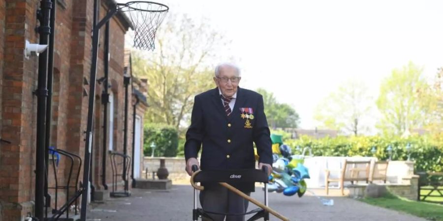 Der 99-jährige Kriegsveteran Tom Moore unterwegs mit seinem Rollator. Foto: Joe Giddens/PA Wire/dpa