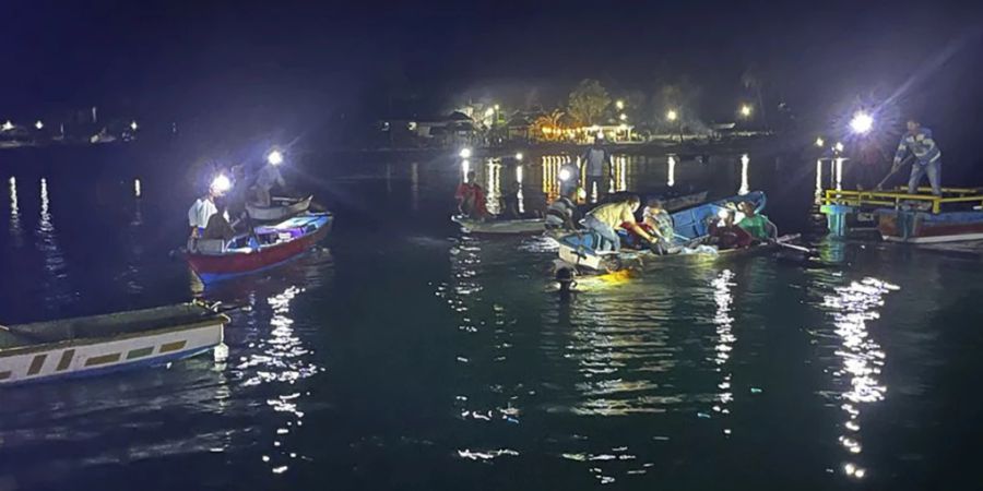 HANDOUT - Anwohner und Mitarbeiter der Behörde such nach Überlebenden, nachdem eine Fähre vor der indonesischen Insel Sulawesi gekentert ist. Foto: BASARNAS/AP/dpa - ACHTUNG: Nur zur redaktionellen Verwendung und nur mit vollständiger Nennung des vorstehenden Credits