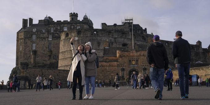 Touristen schiessen ein Selfie vor der Burg von Edinburgh. schottland