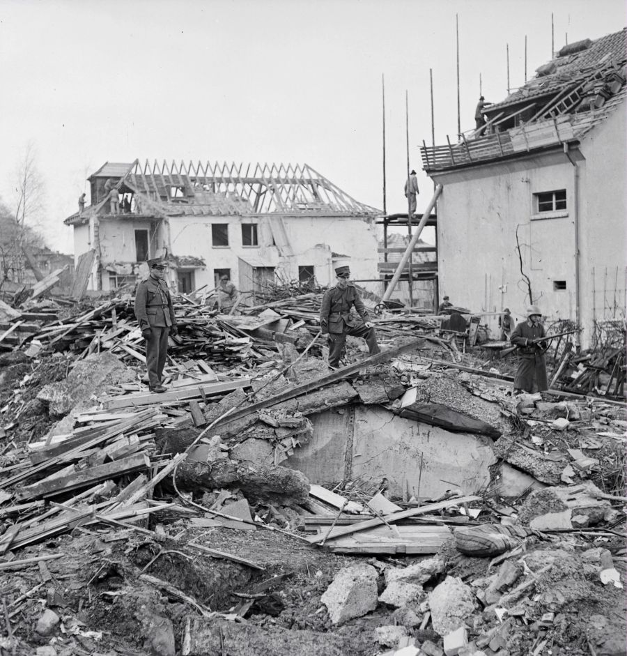 Einsatzkräfte in einem Trümmerhaufem.