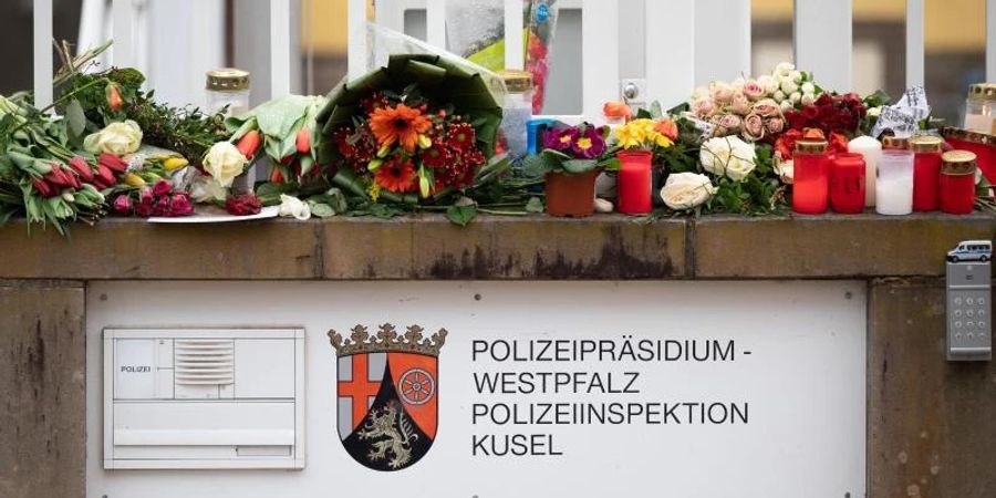 In Gedenken an die ermordeten Beamten: Passanten haben Blumen und Kerzen vor der Polizeiinspektion Kusel gelegt. Foto: Sebastian Gollnow/dpa