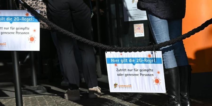 Vor einem Geschäft für Bastelbedarf in der Mainzer Innenstadt hängen Hinweisschilder mit der Aufschrift "Hier gilt die 2G-Regel. Foto: Arne Dedert/dpa