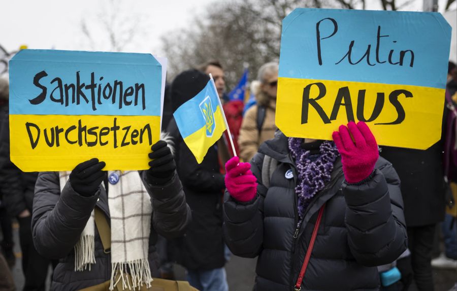 Demonstranten halten Transparente und ukrainische Flaggen während der Friedensdemo in Bern am 2. April 2022.