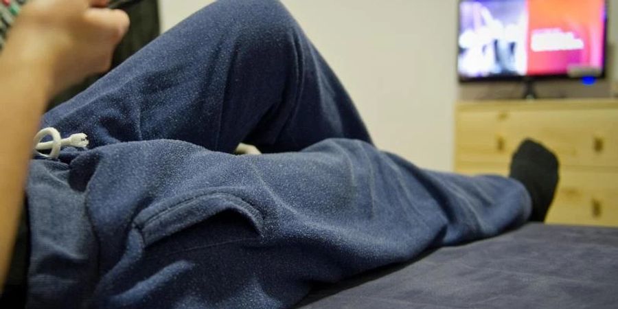 Relaxen auf der Couch in einer Jogginghose. Die Pandemie stellt Paarbeziehungen auf die Probe. Foto: Christoph Schmidt/dpa