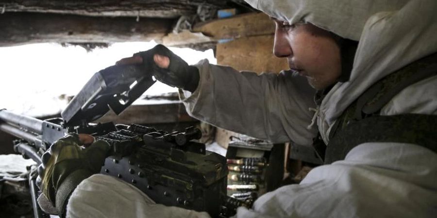 Ein ukrainischer Soldat überprüft ein Maschinengewehr in einem Unterstand in einem von prorussischen Kämpfern kontrollierten Gebiet. Foto: Alexei Alexandrov/AP/dpa