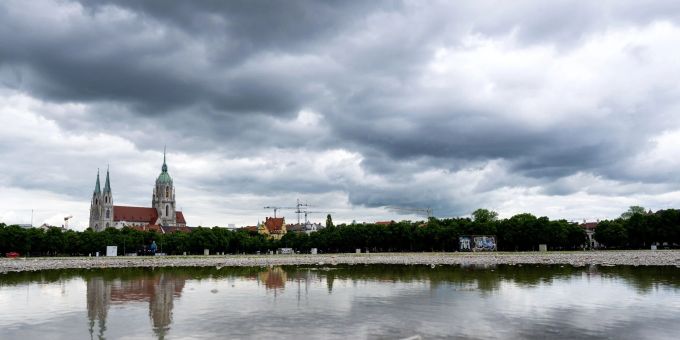 Dunkle Wolken ziehen über Theresienwiese in München. Im Hintergrund steht die Kirche St. Paul. Dunkle Wolken ziehen über Theresienwiese in München. Im Hintergrund steht die Kirche St. Paul.