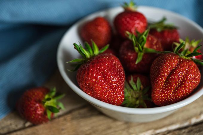 Erdbeeren sind ein leckerer Snack für zwischendurch oder als Dessert – zum Beispiel nach Spargel. Erdbeeren rot Stängel Schälchen Holz