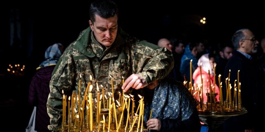 Ukrainischer Soldat zündet Kerze in Kirche in Kiew an