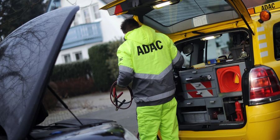 Ein ADAC-Pannenhelfer mit Starthilfekabel im Einsatz.