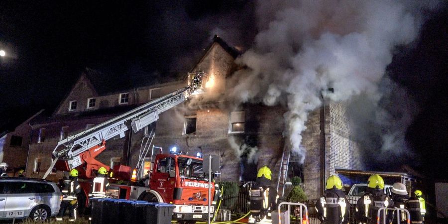 Feuerwehrleute bekämpfen den Brand eines Mehrfamilienhauses in Wesel.