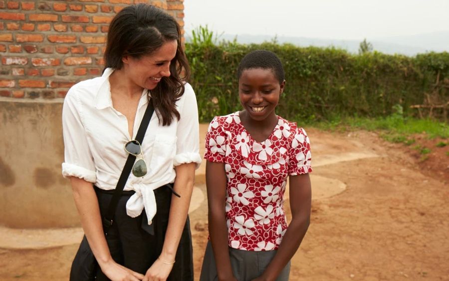 Meghan Markle lacht mit einem der Dorfkinder.