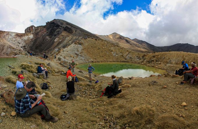 Aus Respekt vor den Maori sollte man nicht überall am Weg snacken: Die Emerald Lakes sind aber ein geeigneter Platz für die Mittagspause. Wandergruppe See Picknick Felsen Vulkan