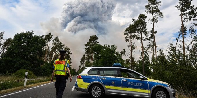 Ein Polizeiauto sperrt die Strasse im Waldbrandgebiet in der sächsischen Gohrischheide ab. Ein Polizeiauto sperrt die Strasse im Waldbrandgebiet in der sächsischen Gohrischheide ab.