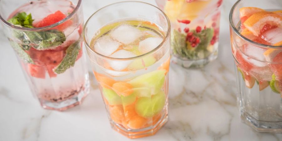 Alles, was hilft, um an heissen Tagen mehr zu trinken: Mit Kräutern, Obst- und Gemüseschnitzen lässt sich Wasser wunderbar aufpeppen.