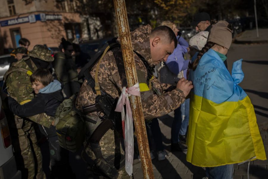 Ein Soldat unterschreibt die ukrainische Fahne eines jungen Mädchens in Cherson, 14. November 2022.