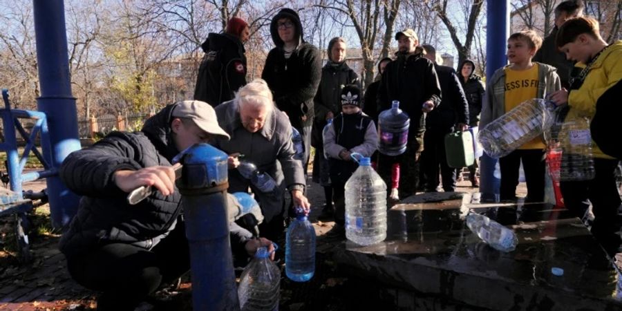 Einwohner füllen an einer Wasserpumpe in Kiew ihre Kanister