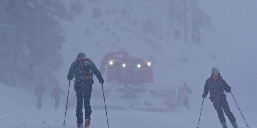 Zwei Skitourengeher und eine Pistenraupe im vergangenen Winter im oberbayerischen Skigebiet Spitzingsee in Oberbayern.