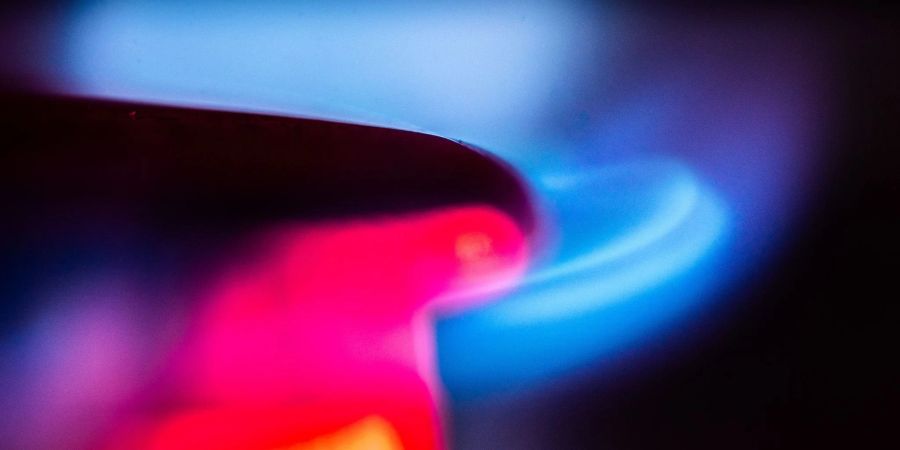 Die Flamme eines Gasherdes brennt in einer Küche.