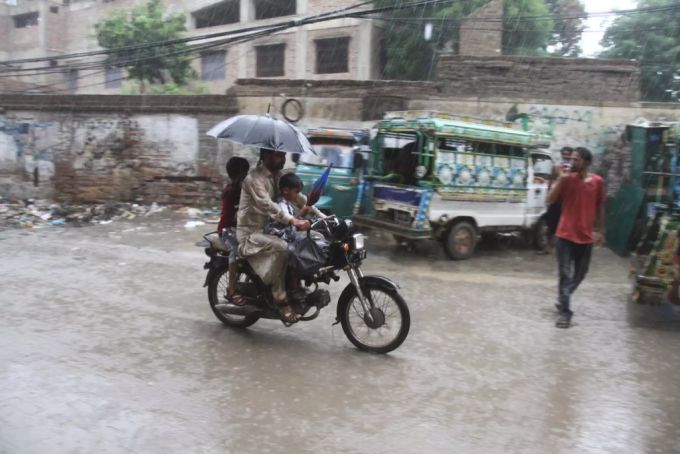 Ein Mann fährt auf einem Motorrad durch den Starkregen in Pakistan. Pakistan