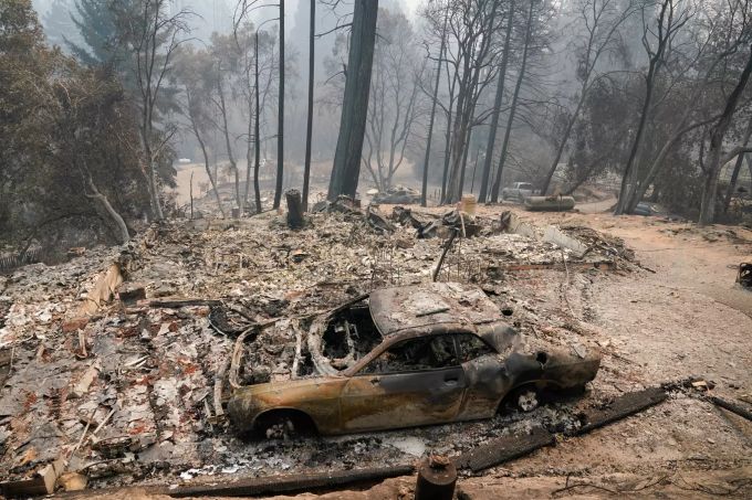 Ein ausgebranntes Auto steht in der Nähe eines Waldes in Kalifornien. Waldbrände in Kalifornien