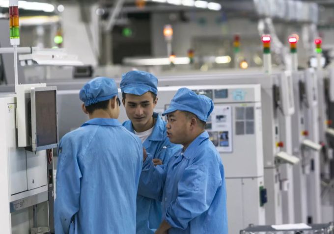 Menschen arbeiten an Maschinen in der Fxconn-Fabrik in China. China