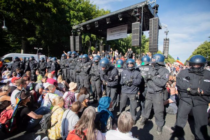 Polizisten stehen bei einer Kundgebung gegen die Corona-Beschränkungen auf der Strasse des 17. Juni zwischen Teilnehmern vor einer Bühne. Die Polizei hat die Veranstaltung aufgelöst. Foto: Christoph Soeder Demonstration gegen Corona-Massnahmen in Berlin