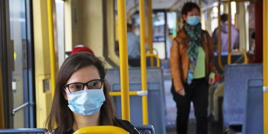 Fahrgäste einer Kölner Stadtbahn tragen Schutzmasken. Foto: Oliver Berg/dpa