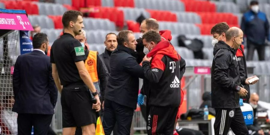 Bayern-Trainer Hansi Flick spricht mit Alphonso Davies bei der verletzungsbedingten Auswechslung. Foto: Matthias Balk/dpa