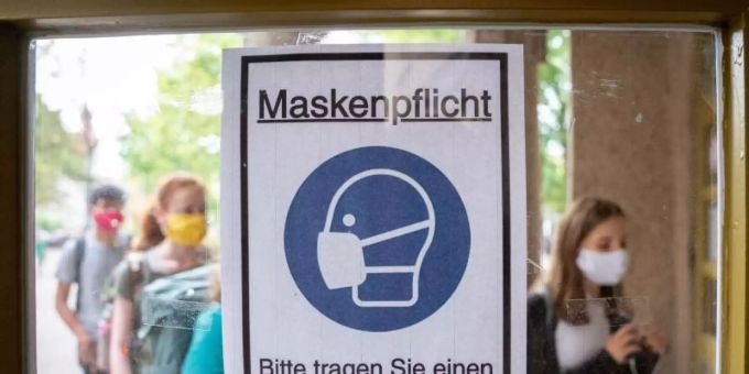 Schüler betreten hinter einem Plakat mit der Aufschrift «Maskenpflicht» am ersten Tag nach den Sommerferien den Eingang zum Rheingau Gymnasium in Berlin. (Symbolbild) Maskenpflicht schule