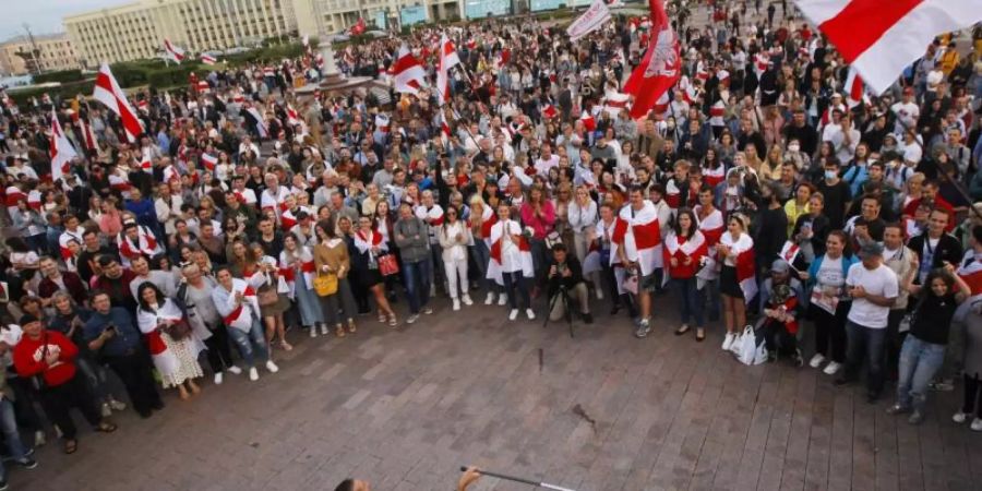 Anhänger der Opposition nehmen an einem Protest vor dem Regierungsgebäude teil. Foto: Dmitri Lovetsky/AP/dpa