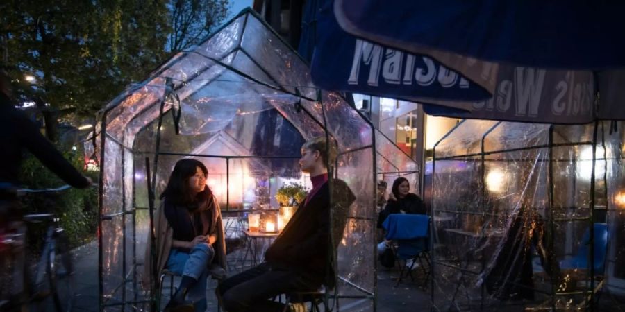 Gäste einer Berliner Bar unter einem Schutzdach