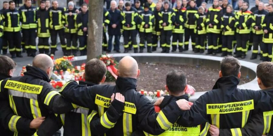 Feuerwehrmänner trauern am Königsplatz in Augsburg. Foto: Stefan Puchner/dpa/Archiv